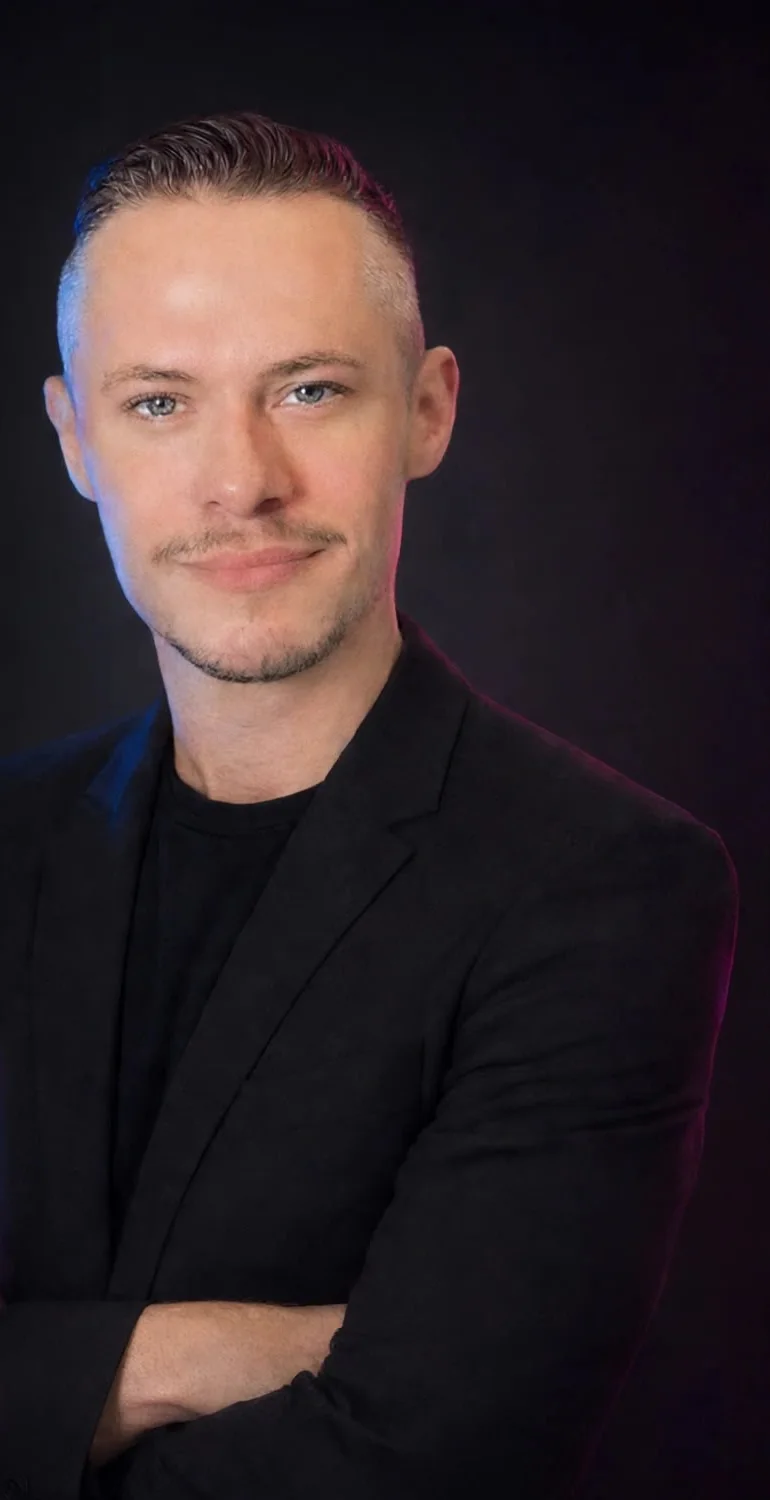 Lucas Thompson, owner-developer of TECHGURU, arms crossed in a black blazer